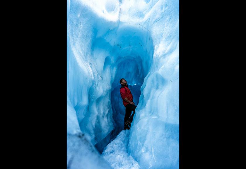Person deep in an blue ice tunnel