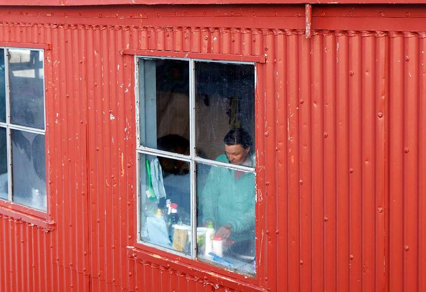 Person in the window preparing food in a red cabin