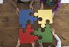 4 people connecting puzzle pieces