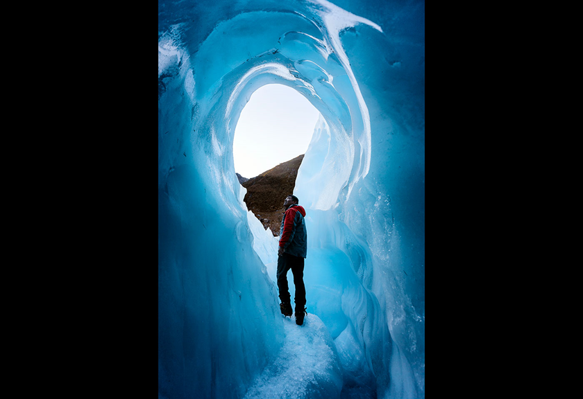 Explorer in the middle of a ice tunnel