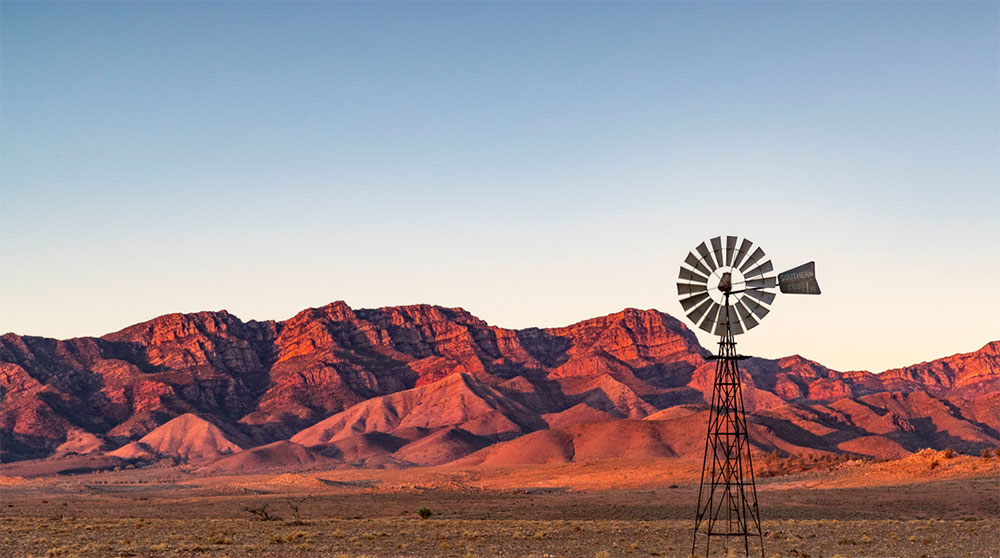 Windmill with picturesque red mountain behind