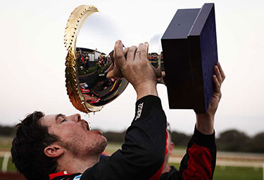 Image of winning racer holding his trophy photographed by T McLeod
