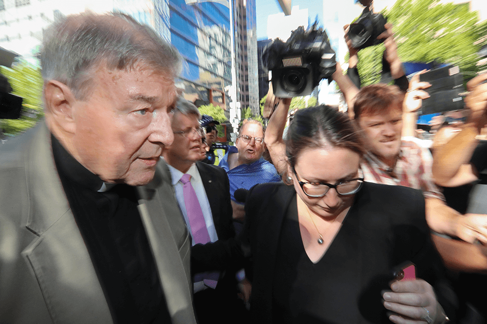 George Pell arrives at the County Court in Melbourne in 2019. A man yelling abuse is in the background in blue. Canon EOS-1D X Mark II, Canon EF 16-35mm f/2.8L II USM lens @ 16mm. 1/250s @ f18, ISO 3200.