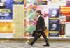 Man walking past colourful posters