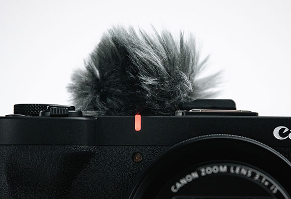Up close image of a Canon camera with focus on the mic wind screen