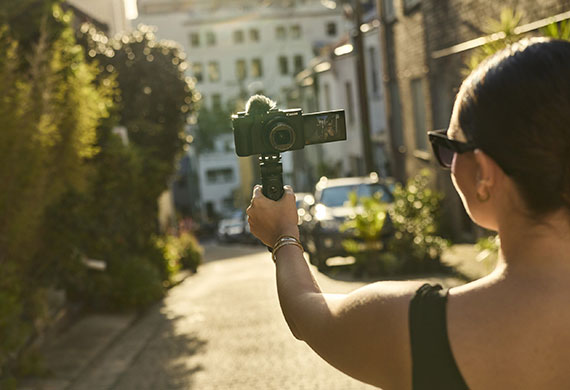 Image of a woman using a Canon camera in a tripod to vlog