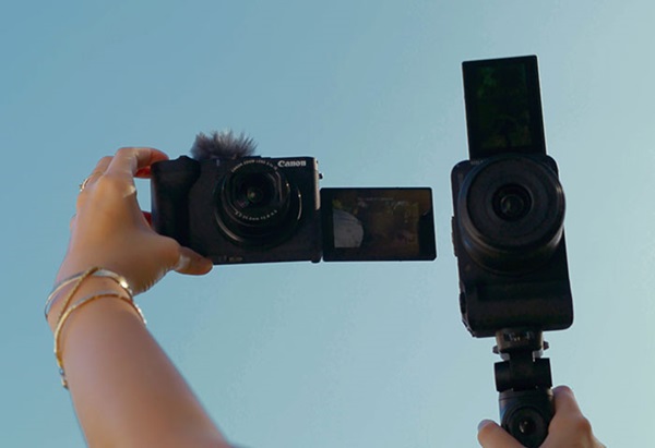 Image of the PowerShot V1 and EOS R50 V cameras on hand