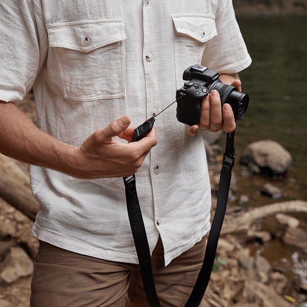 Model holding the EOS R50 with the Status Anxiety leather strap photographed by Leni Ali Studios