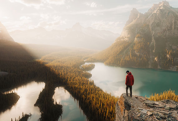Image of a traveller loooking at the mountains and lake
