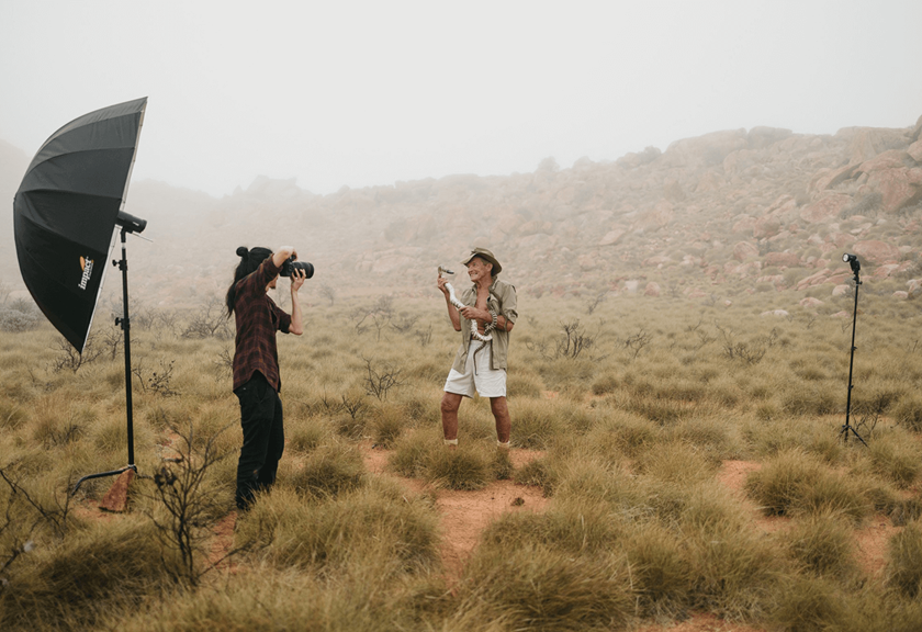 Jarrad Seng taking a photo of Brian Bush holding a snake