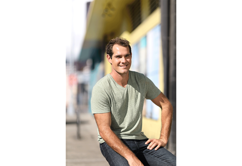 image of man in green shirt sitting blurred background