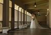 wide shot image of bride with bouquet standing in hallway