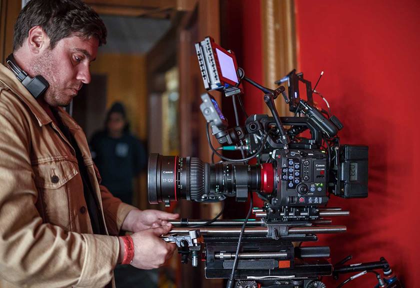  A man meticulously test a large camera in a room, fine-tuning its features and ensuring optimal performance.