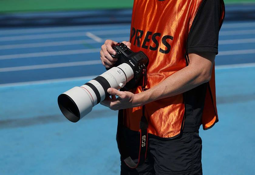 Image of a man holding a Canon EOS R1 with RF 70-200mm f/2.8L IS USM Z lens