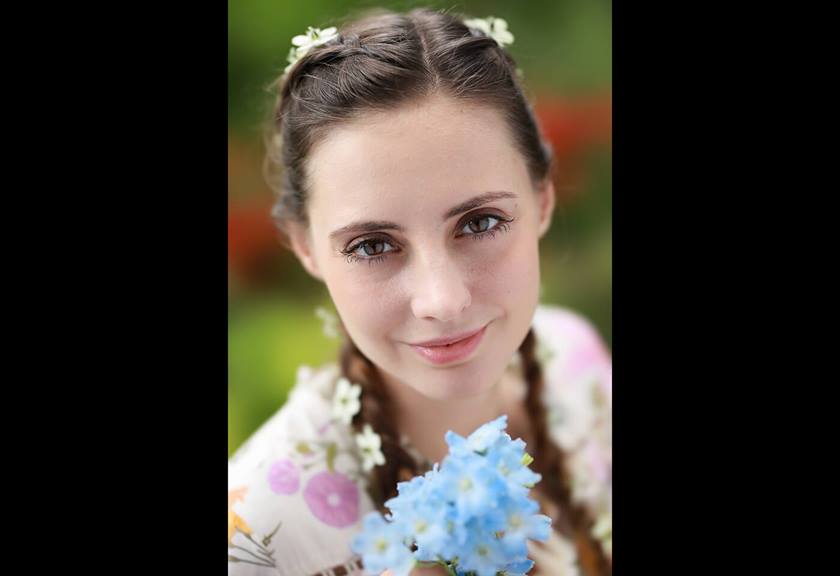 Model holding blue flowers taken using RF 85mm f/1.2L USM DS prime lens