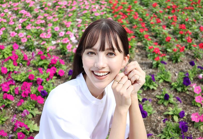 Image of a woman in a flower garden taken using RF 24-50mm f/4.5-6.3 IS STM standard zoom lens