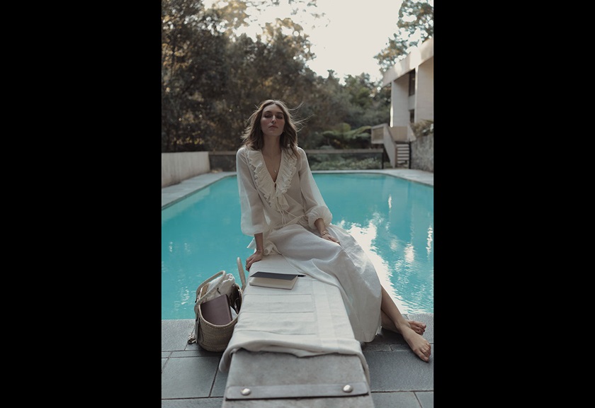 Image of a woman in a white dress sitting near a pool taken by Steven Chee