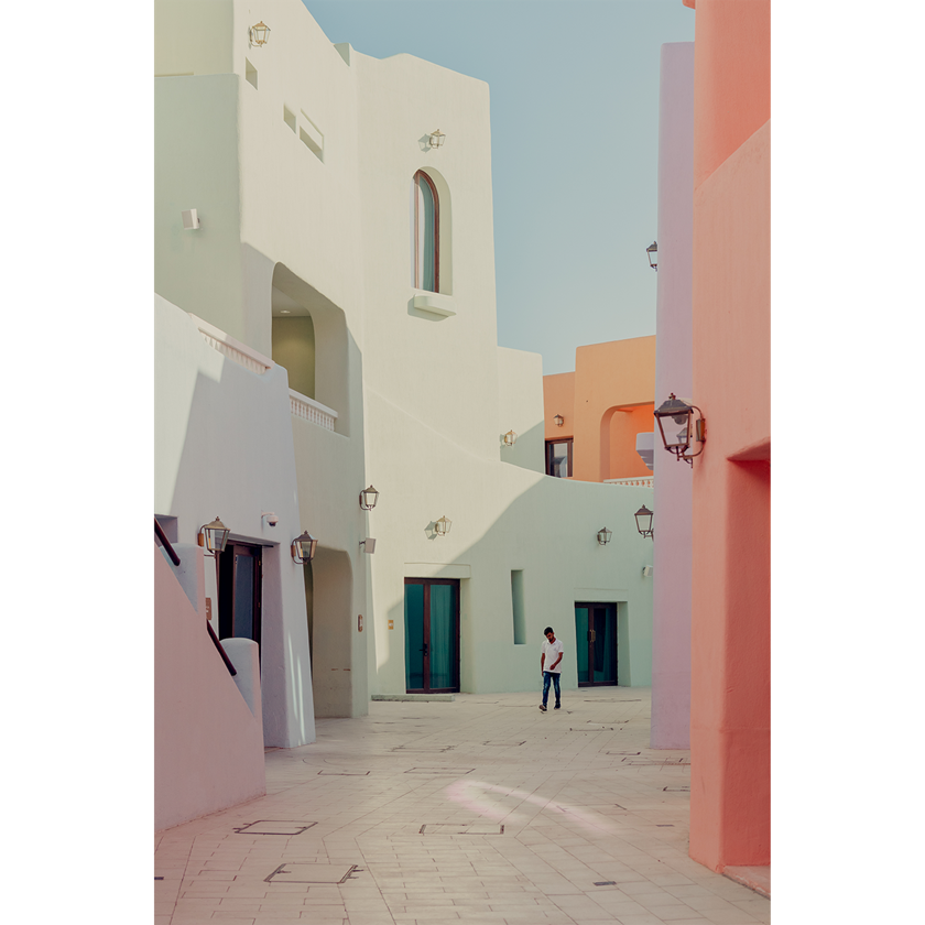 Image of a man walking through colourful buildings in Doha, Qatar