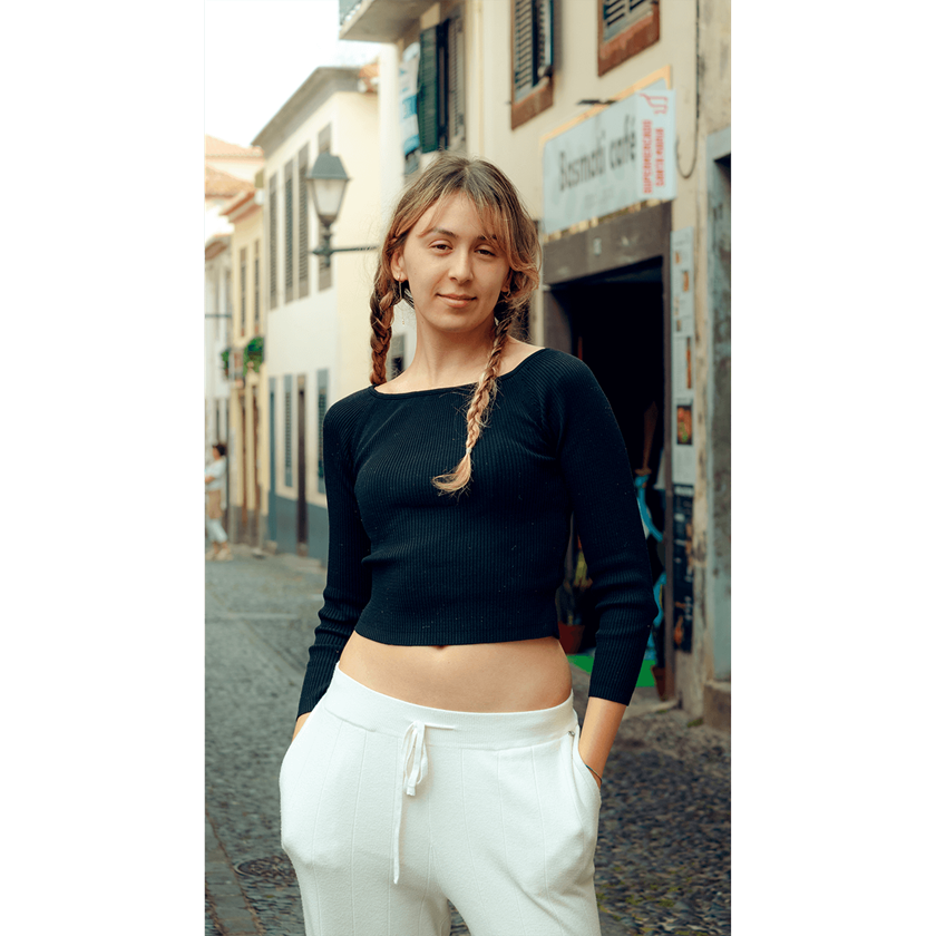 Portrait image of a girl with plaits and black top posing and looking into camera