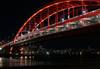 Bridge covered in red lighting at night