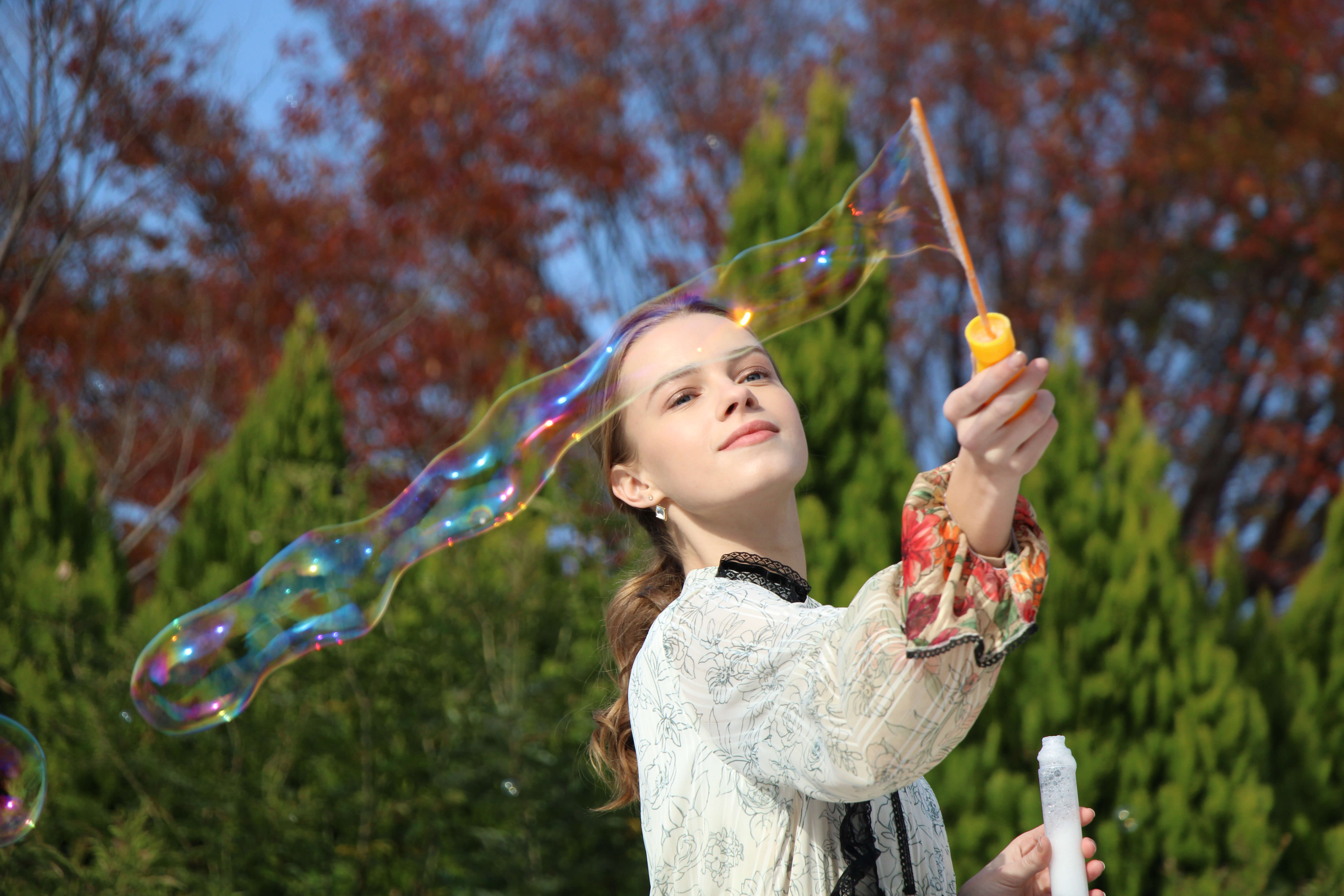 Portrait image of girl clowing bubbles taken with EOS 1500D