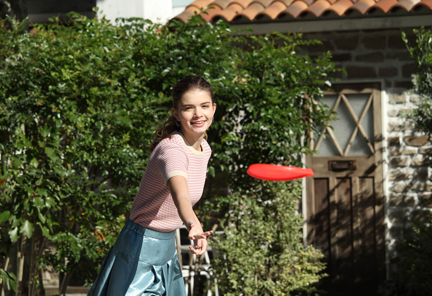 Portrait image of girl playing frisbee taken with EOS 3000D