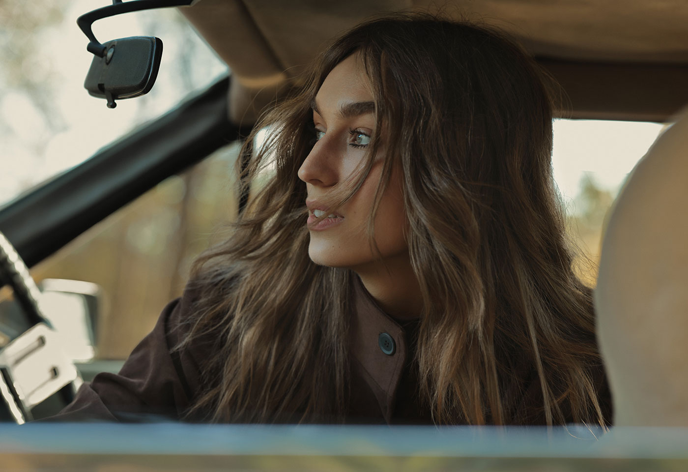 Candid image of a woman on her car looking outside taken with the RF 85mm f/1.4L VCM lens