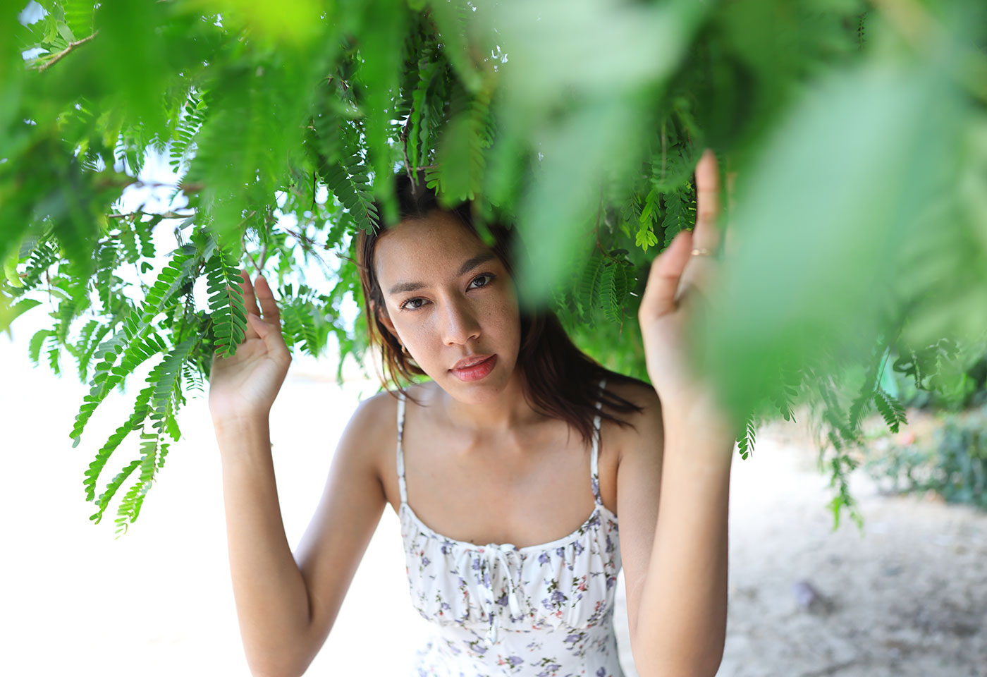 Image of a woman underneath greenery taken using the RF 20mm f/1.4L VCM prime lens