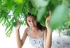 Image of a woman underneath greenery taken using the RF 20mm f/1.4L VCM prime lens