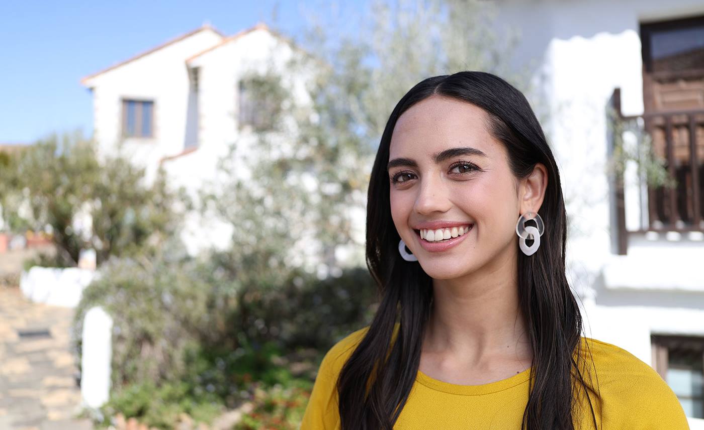 Portrait image of a girl in yellow with houses in the background taken using the RF 28mm f/2.8 STM prime lens