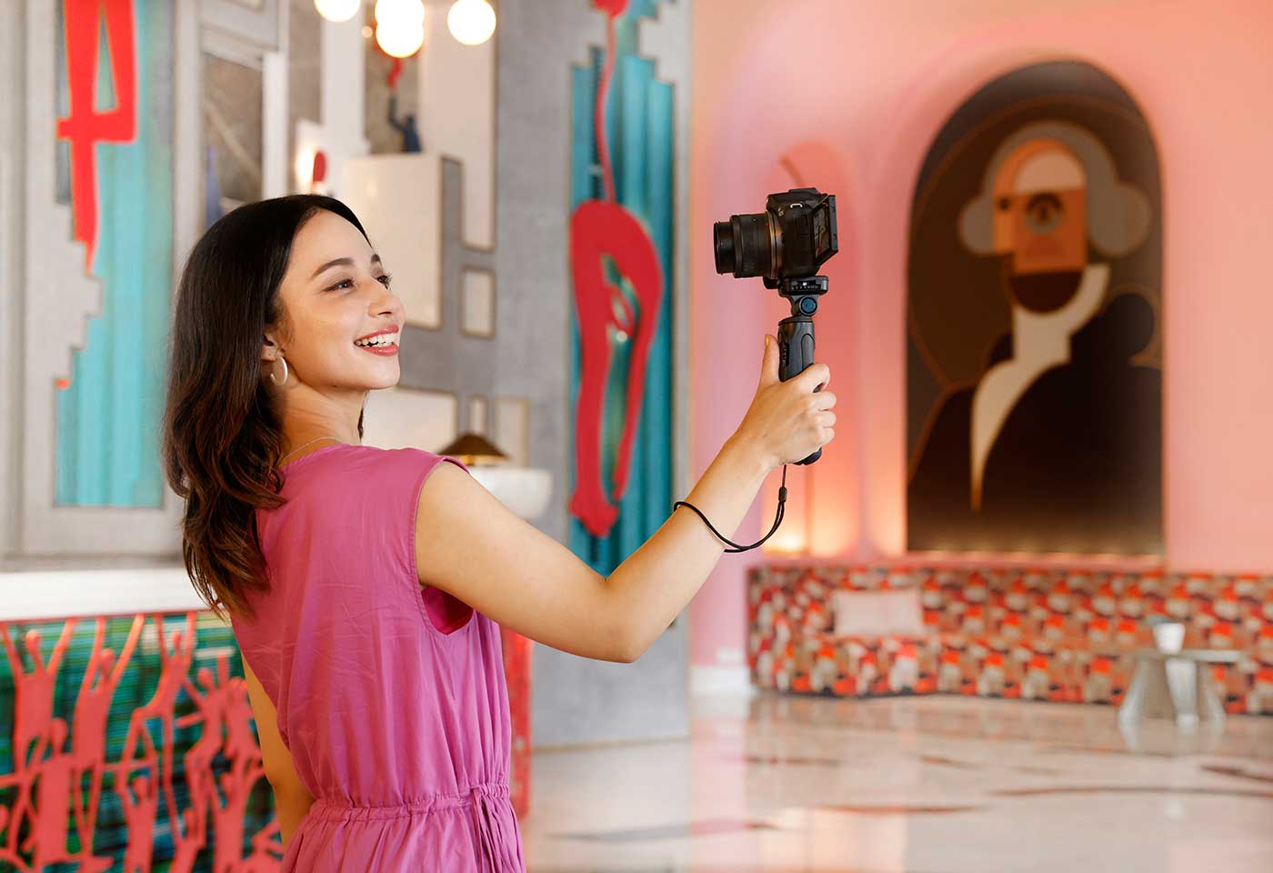 Vlogger using an EOS camera mounted on a selfie stick with the RF-S 10-18mm f/4.5-6.3 IS STM wide angle lens