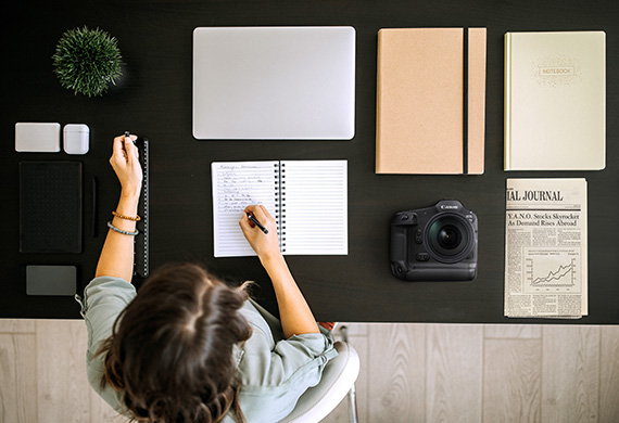Flatlay image of EOS R1 on a work desk