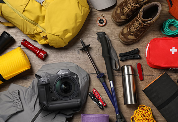 Flatlay image of EOS R1 with outdoor gear