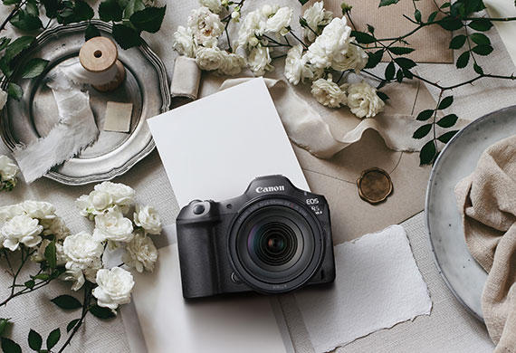 Flatlay image of EOS R5 Mark II on a table with floral arrangements