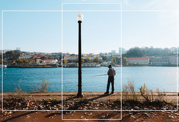 Rule of thirds view of a lake and a man next to a lamp post