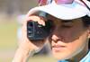 A golf player using the Canon PowerShot GOLF rangefinder