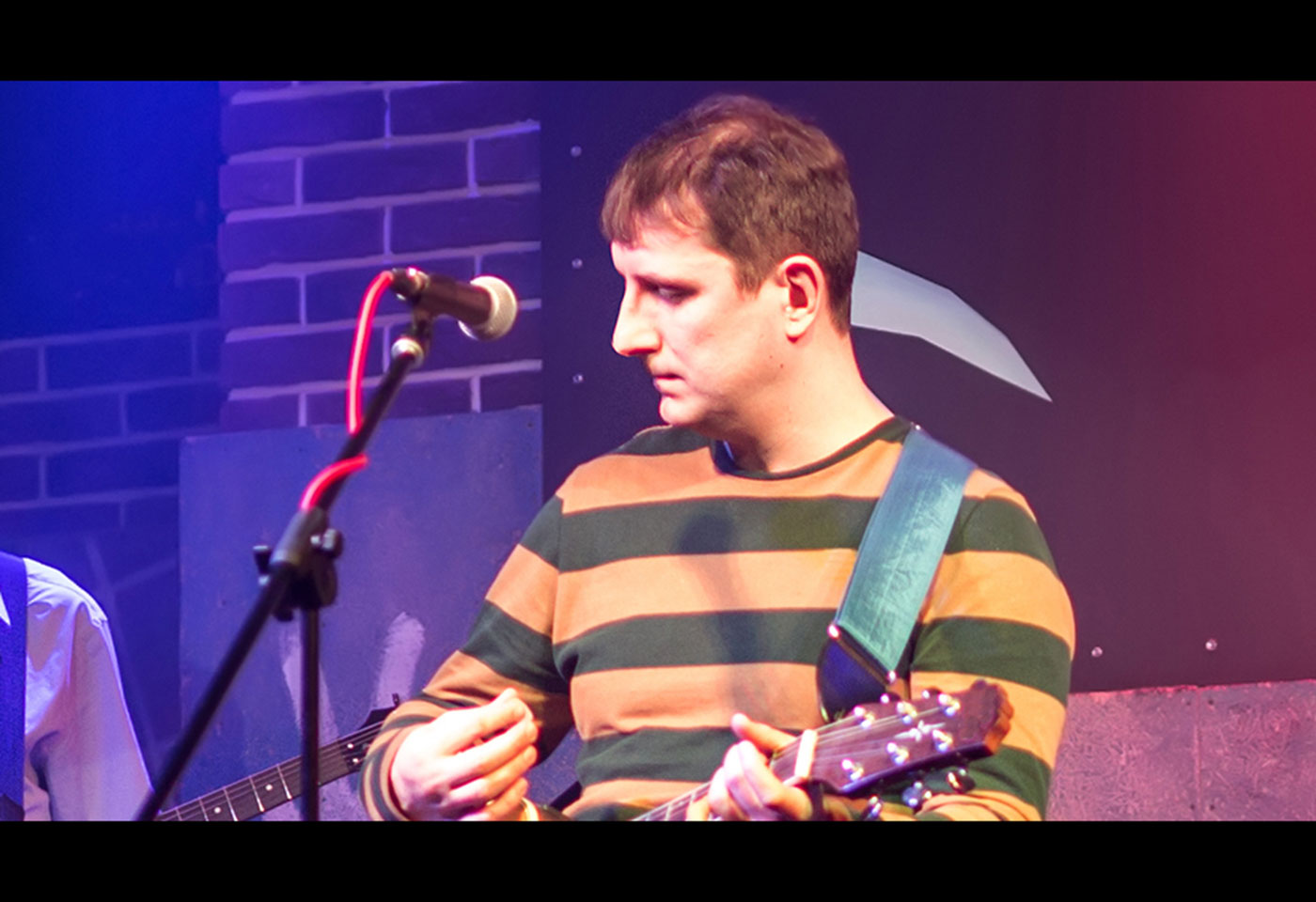Image of a performer playing guitar with a mic in front of him, taken using the CR-N350
