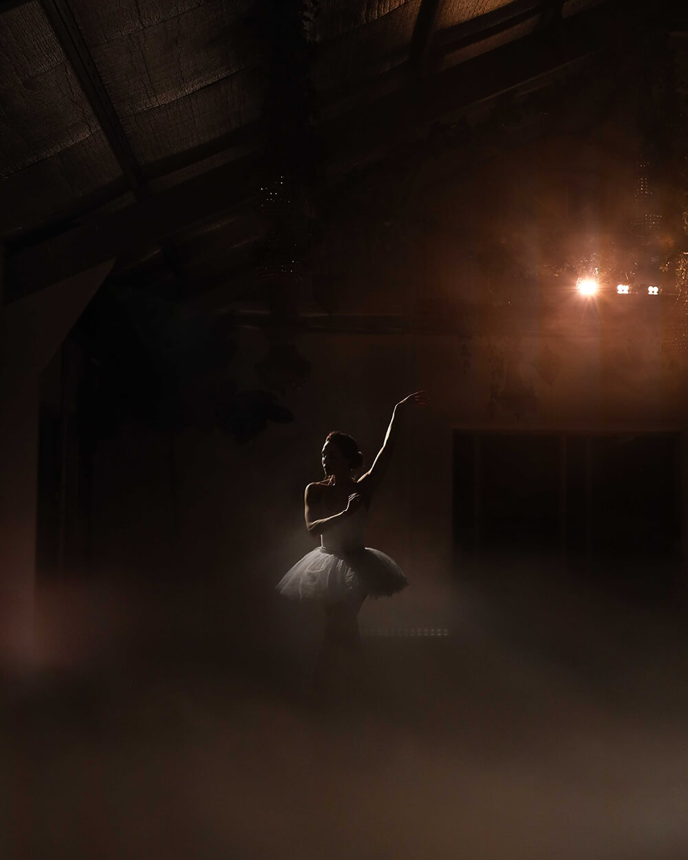 Low light image of ballet dancer in foggy studio by Julian Lallo