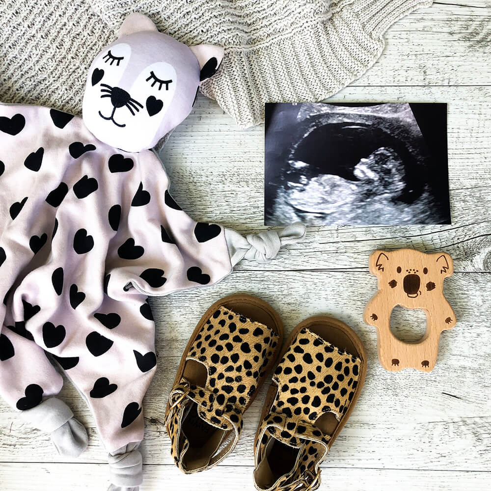 Ultrasound, baby clothes and pair of shoes