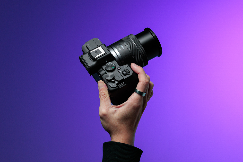 holding EOS R8 Mark II on a gradient background