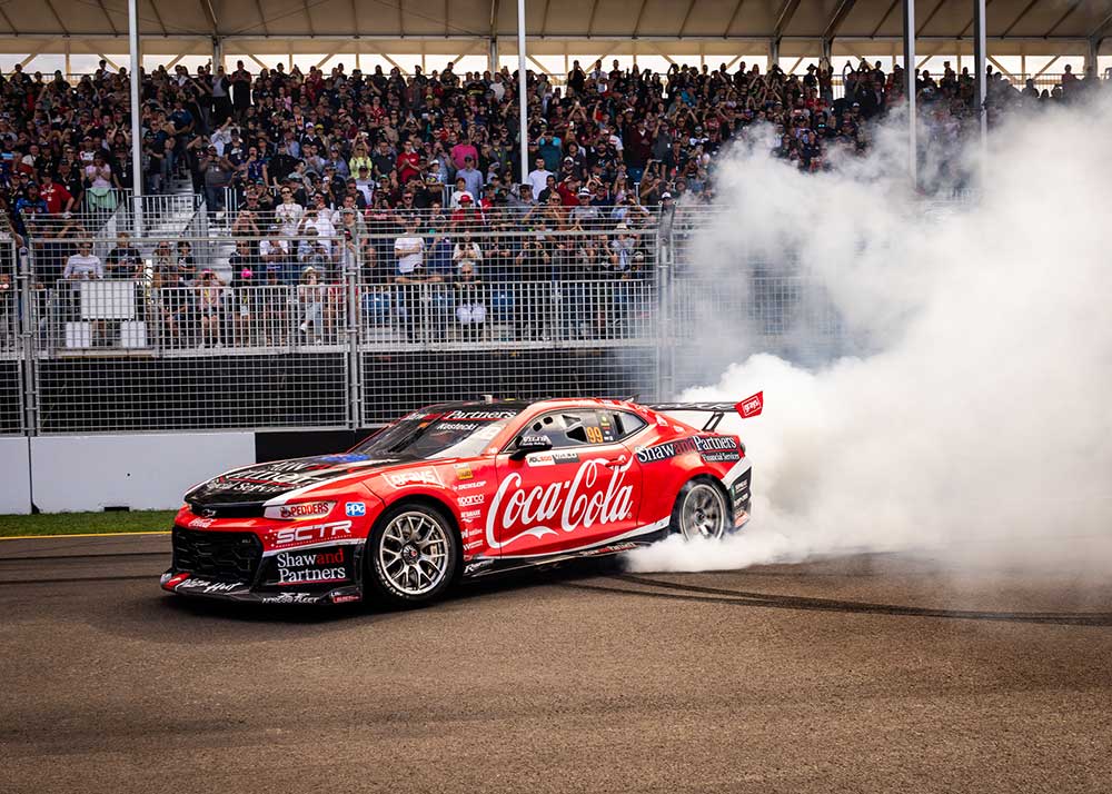 Image of a drifting racecar with lots of smoke photographed by Tenayah McLeod