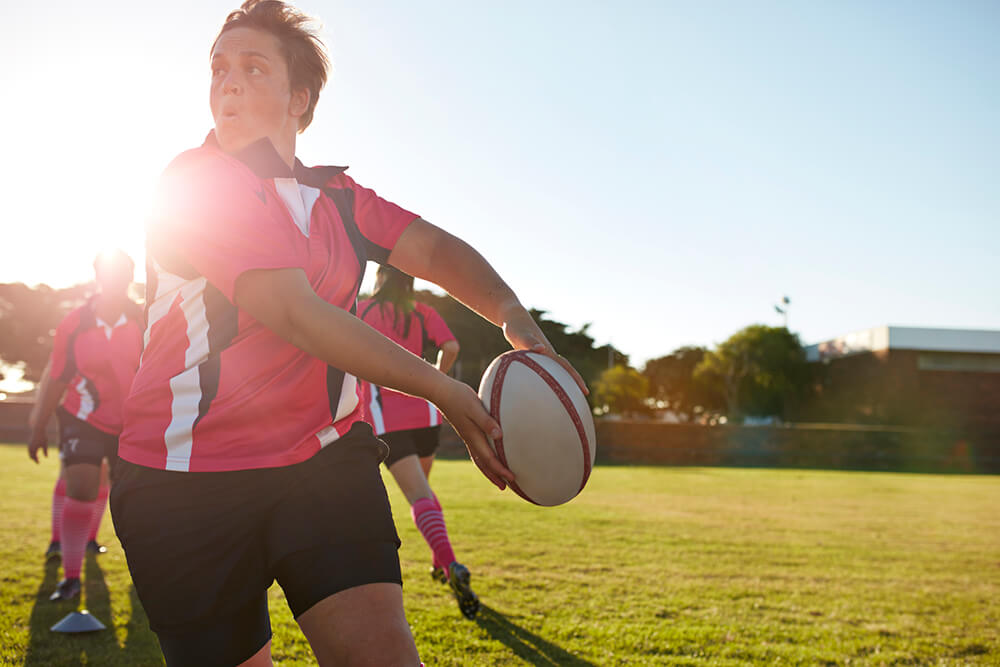 Female team playing rugby on field