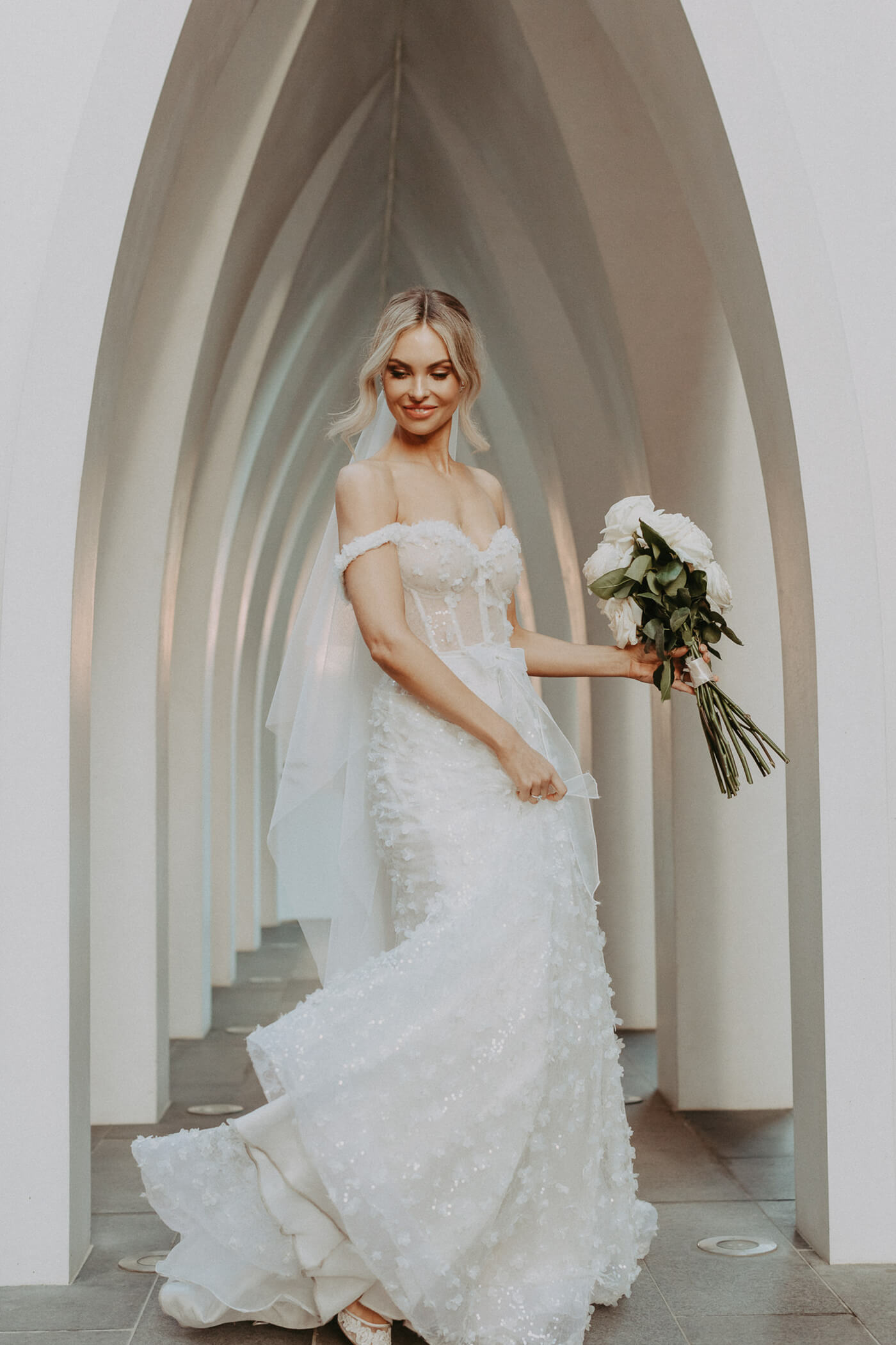 Image of bride holding a bouquet twirling in her dress taken by James Simmons