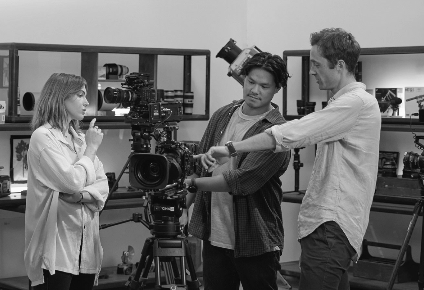 Behind-the-scenes production crew operating cameras and reviewing footage on a film set.