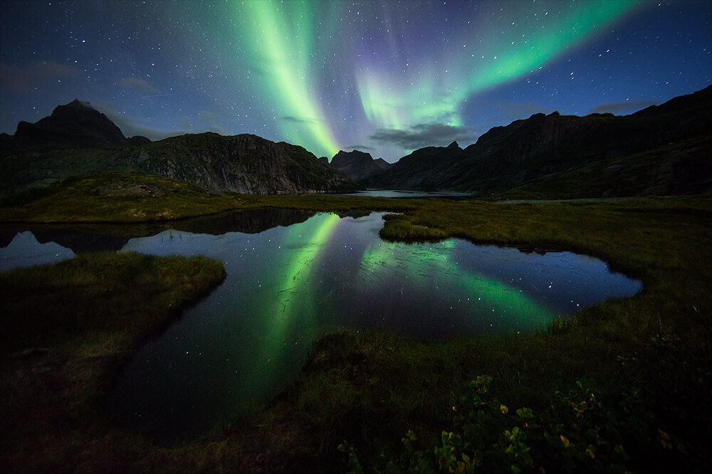 Reflection of the Northern Lights on a lake. Image by Neil Bloem