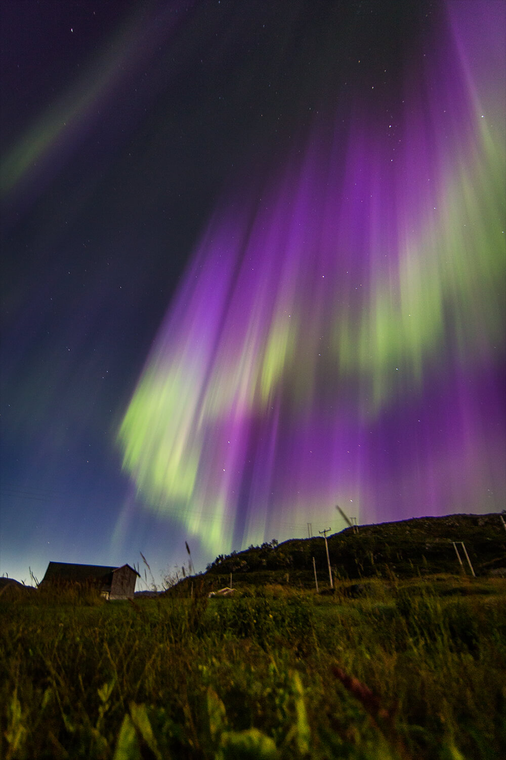Photo of the Aurora Borealis over a cabin in Norway. Photo by Neil Bloem