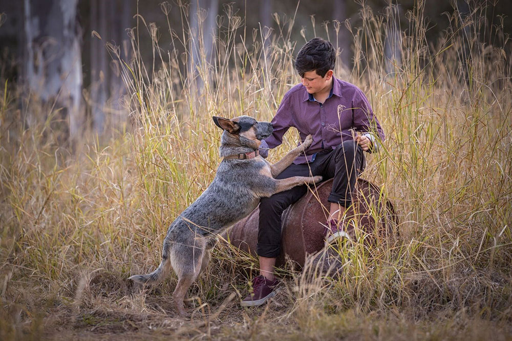 portrait image of boy playing with dog