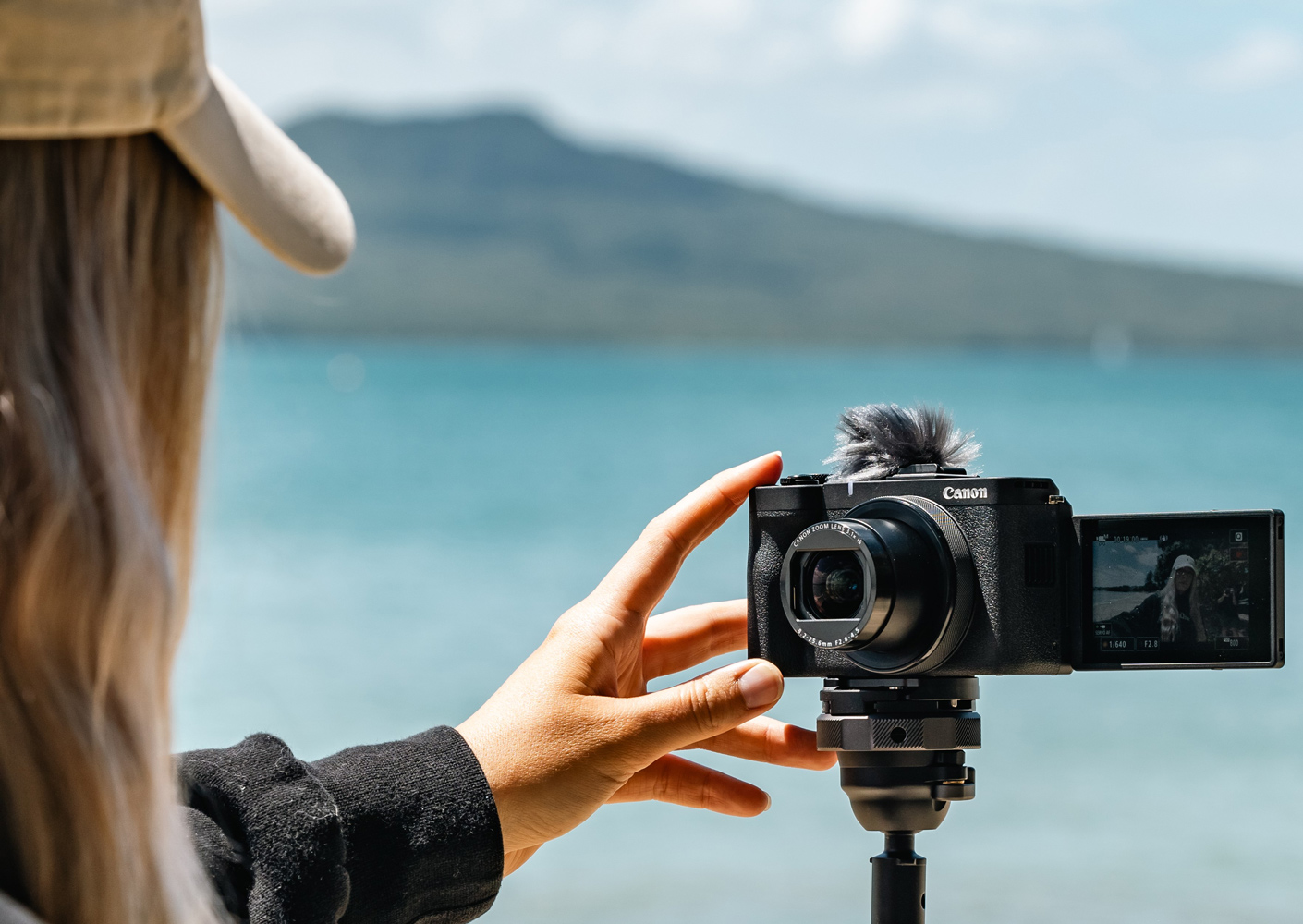 Image of a woman using her PowerShot V1 in the beach