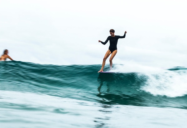 Landscape image of woman surfing by Fran Miller