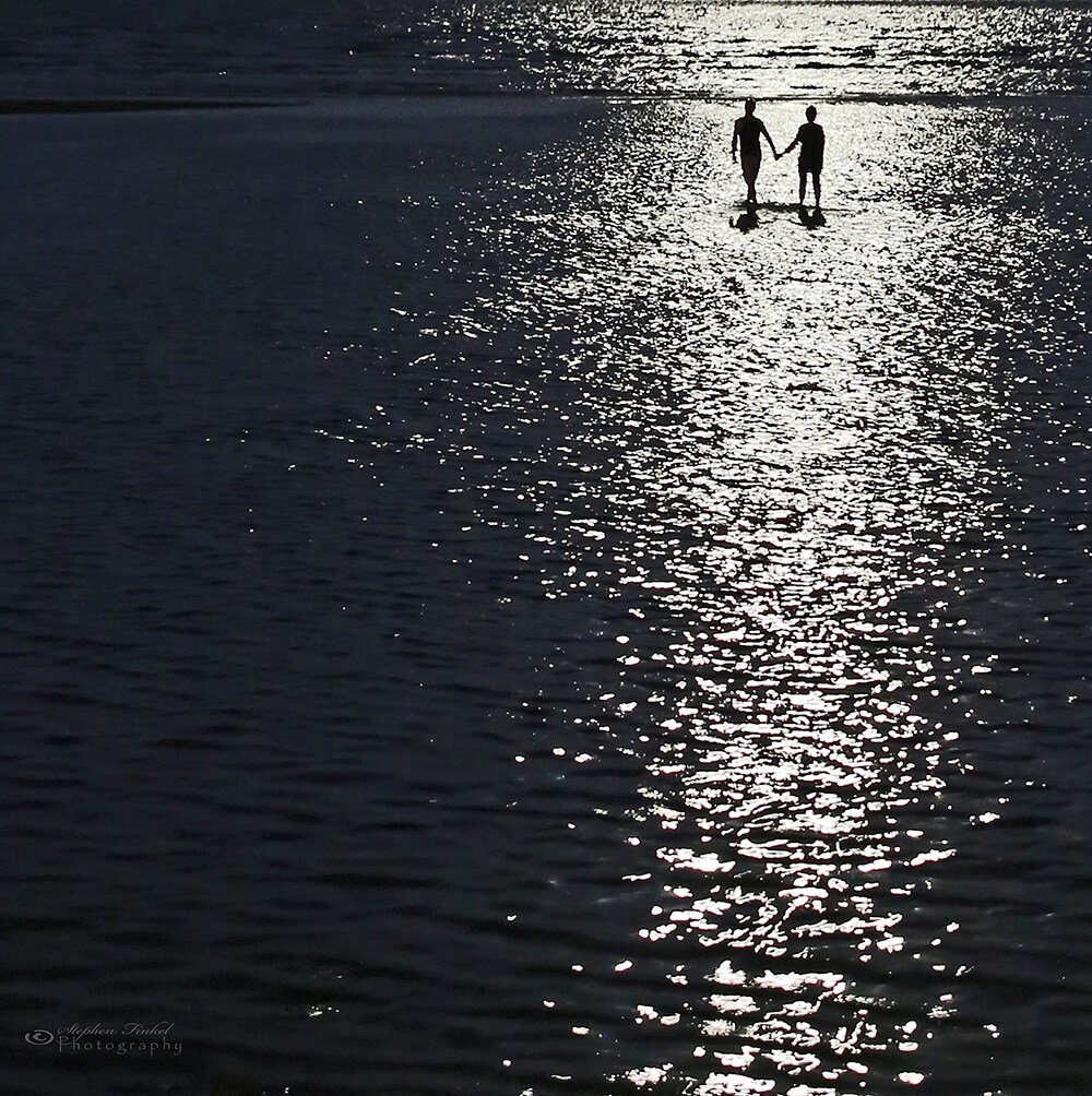 Black and white image of a couple in the ocean taken by Stephen Finkel